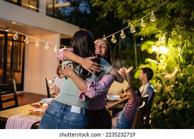 Young Asian woman visit the family during party outdoors in the garden. Attractive diverse group of people having dinner, eating foods, celebrate weekend reunion gathered together at the dining table - Shutterstock ID 2235232719