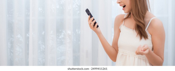 Young asian woman walking using smart phone for video call in living room at home, female using social media on phone for chat online and conversation distant with relax, lifestyle concept. - Powered by Shutterstock