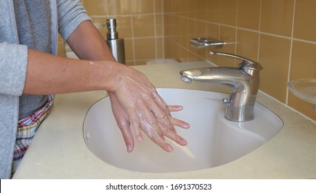 Young Asian woman washing her hands with a hand wash gel .Clean hands protect against infection-right palm over left dorsum with interlaced fingers and vice versa. Coronavirus, Covid-19 protection.