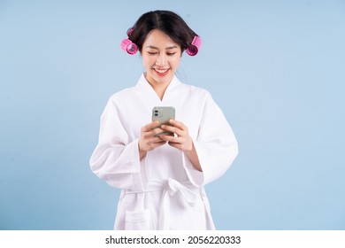 Young Asian Woman Wearing Bathrobe On Blue Background