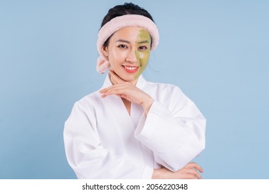 Young Asian Woman Wearing Bathrobe On Blue Background