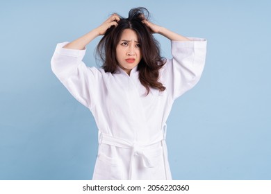 Young Asian Woman Wearing Bathrobe On Blue Background