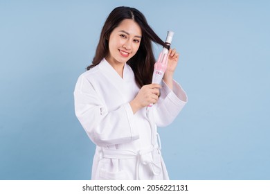 Young Asian Woman Wearing Bathrobe On Blue Background