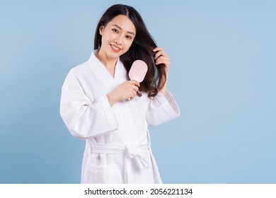 Young Asian Woman Wearing Bathrobe On Blue Background