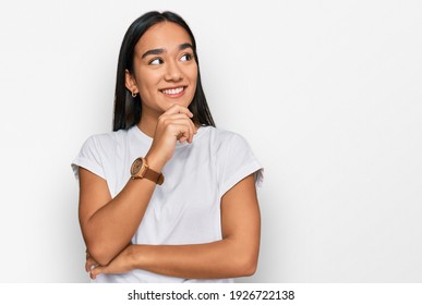 Young Asian Woman Wearing Casual White T Shirt With Hand On Chin Thinking About Question, Pensive Expression. Smiling With Thoughtful Face. Doubt Concept. 