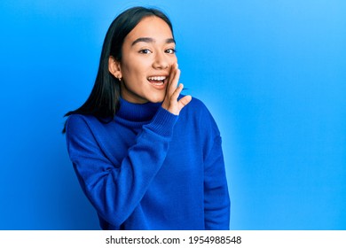 Young Asian Woman Wearing Casual Winter Sweater Hand On Mouth Telling Secret Rumor, Whispering Malicious Talk Conversation 