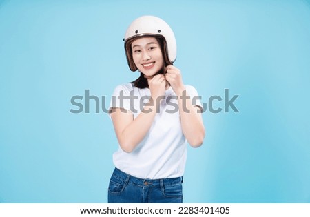 Young Asian woman wearing helmet on background