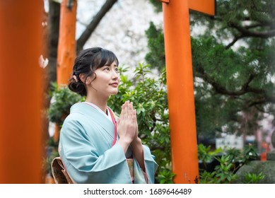 Young asian woman wearing kimono. Prayer in shrine. Japanese traditional clothes.