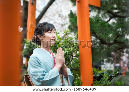 Young asian woman wearing kimono. Prayer in shrine. Japanese traditional clothes.