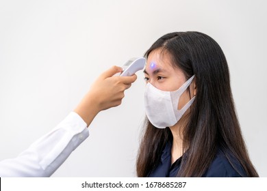 Young Asian Woman Wearing N95 Mask, Getting Her Temperature Check - Health Concept