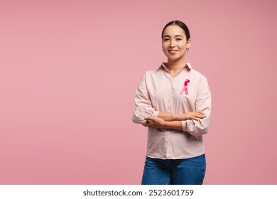 Young Asian woman wearing pink shirt with pink ribbon showing support for breast cancer awareness on pink background. Health care, support concept - Powered by Shutterstock