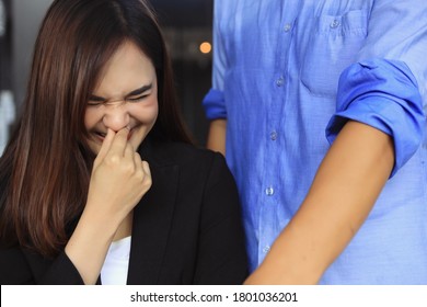 A Young Asian Woman Who Covers Her Nose Because Of The Sweat And Body Odor Of Her Coworkers.