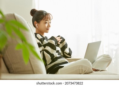 A young Asian woman working on her computer at home - Powered by Shutterstock