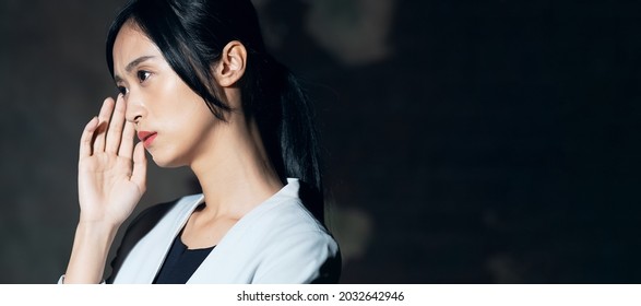 Young asian woman worrying in the dark. - Shutterstock ID 2032642946