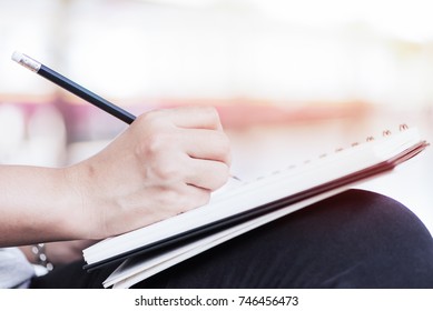 Young Asian Woman Writing On Notebook At Railway Station
