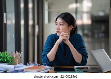 Young Asian women are bored at work and feel lazy to deal with data on their laptops. - Powered by Shutterstock