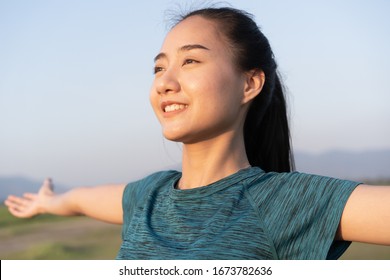 Young Asian women are exercising with yoga while standing outdoor in summer at morning, Asia girl take care of their health with meditation. Close- up of smile on face. Concept wellness and lifestyle
