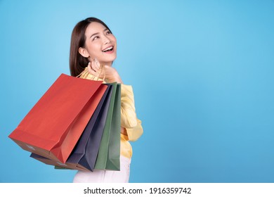 Young Asian Women Are Happy To Go Shopping, Isolated On Blue Background.