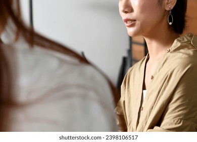 Young Asian women having a conversation at a restaurant - Powered by Shutterstock