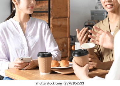 Young Asian women having a conversation at a restaurant - Powered by Shutterstock