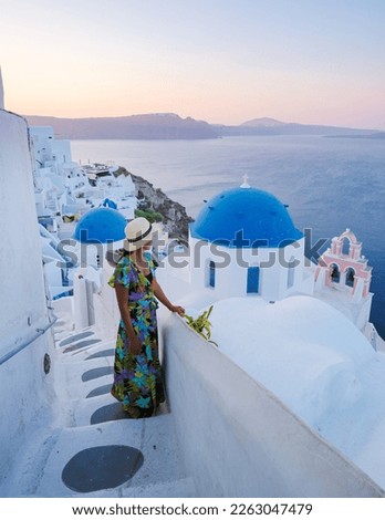 Young Asian women on vacation in Santorini Greece, a girl with hat at the Greek village in Santorini. 