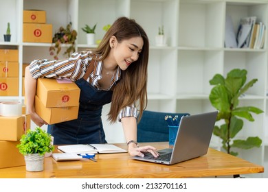 Young Asian Women Start Small Business Successful SME Entrepreneur .freelance Work-at-home woman with the laptop to take orders and deliver parcels online. SME delivery concept and packaging