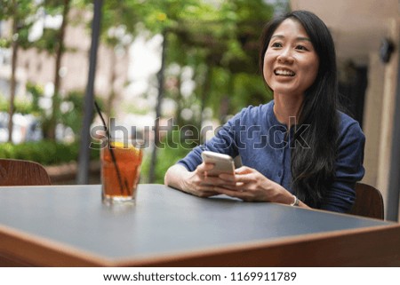 Young Asian women using smartphone and smiling