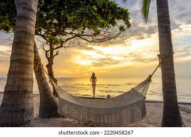 Young asian women watching the sunrise in a hammock on a tropical beach in Hua Hin Thailand. Asian women in a hammock on the beach of Hua hin, Thailand