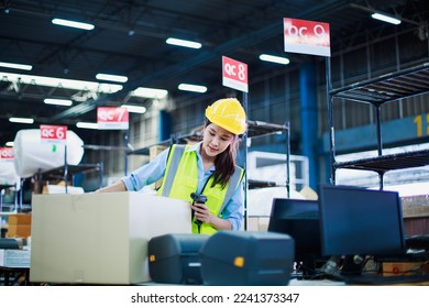 Young Asian women wear yellow helmet stand Check in counter for pick-up and delivery and using holding barcode scanner in warehouse. import export shipping logistics industrial transportation concept - Powered by Shutterstock