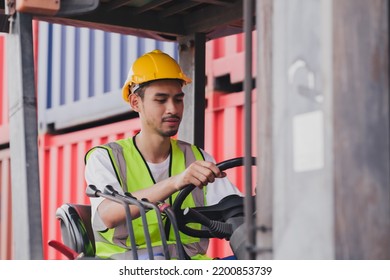 Young Asian Work Man Driving The Truck Over Construction Site. Industrial Factory Worker Operating On Forklift In The Import Export Shipyard. Foreman At Warehouse Logistic In Cargo Freight Ship.