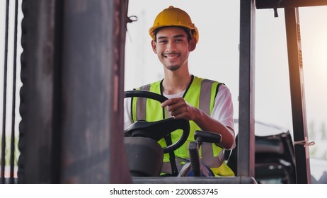 Young Asian Work Man Driving The Truck Over Construction Site. Industrial Factory Worker Operating On Forklift In The Import Export Shipyard. Foreman At Warehouse Logistic In Cargo Freight Ship.