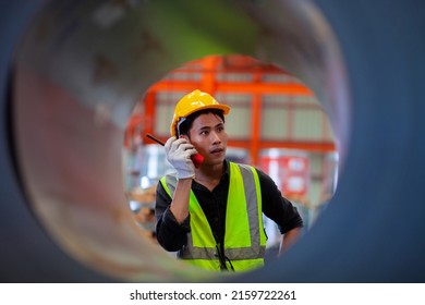 Young Asian Worker Inspecting The Steel Industry Production In The Factory. Asian Male Engineer Production Control Worker And The Sheerness Of The Warehouse
