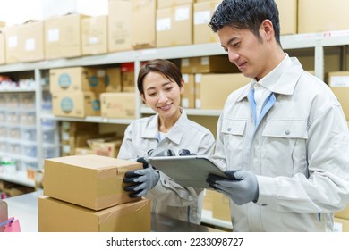 young asian workers working together in warehouse - Powered by Shutterstock