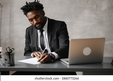 A Young Aspiring African-American Investor Works At A Computer, Analyzes The Securities Market