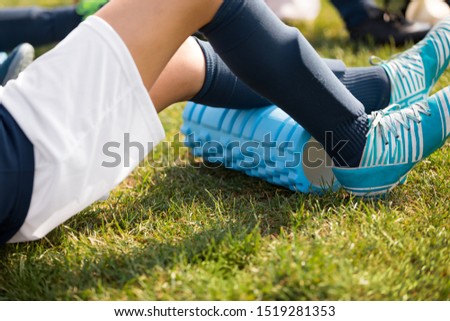 Young Athlete Boy Using Foam Roller on Sports Training. Soccer Player on Warm-up Cooldown After Outdoor Practice
