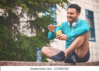 Young Athlete Man Eating Fruit After Exercising. 