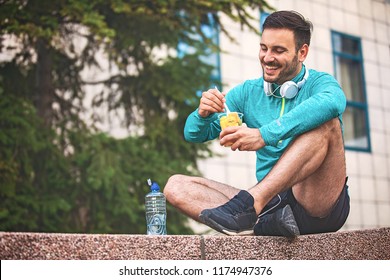 Young Athlete Man Eating Fruit After Exercising. 