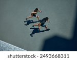 Young, athlete man and woman in sporty attire running together during pair workout on sunny summer day. Fit couple. Concept of sport and healthy lifestyle, pair training, leisure activity.