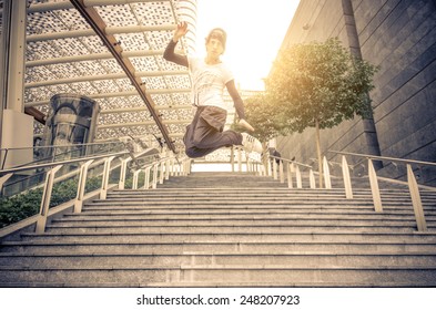 Young athlete performing parkour tricks - Free runner jumping a stairway  - Powered by Shutterstock