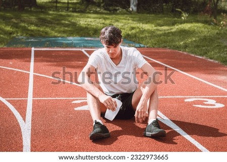 Similar – Image, Stock Photo Young athlete refreshes himself with water after a hard workout on the athletic oval in the intense heat. Endurance training. Brown-haired adolescent