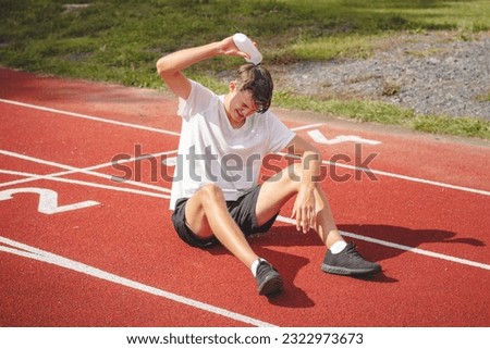 Similar – Image, Stock Photo Young athlete refreshes himself with water after a hard workout on the athletic oval in the intense heat. Endurance training. Brown-haired adolescent
