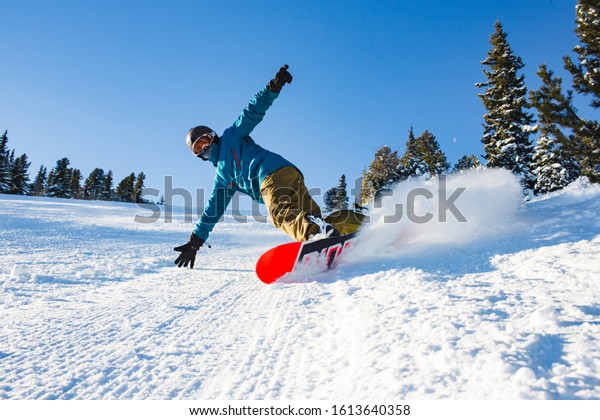 A young athlete is snowboarding. Sunny\
day at the ski resort in Bulgaria,\
Borovets