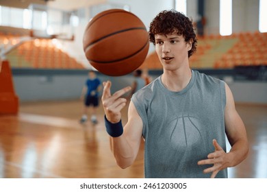 Young athlete spinning a basketball on his finger while exercising at sports court.  - Powered by Shutterstock