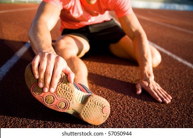 Young Athlete Stretching On The Treadmill Stadium. Unrecognizable