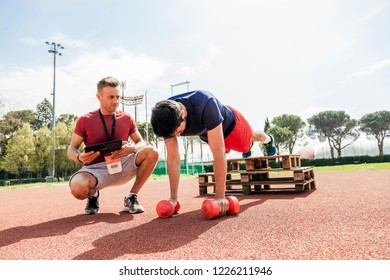 young athlete while exercising doing push-ups on the arms in an outdoor sports stadium
