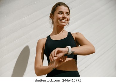 Young athlete woman looking at smartwatch and counting calories burned. Healthy life concept  - Powered by Shutterstock