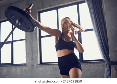 Young athlete woman using landmine barbell in motion at gym. Young fit woman doing exercises for press. Concept of professional sport, active lifestyle, bodybuilding, fitness, motivation, energy. Ad - Powered by Shutterstock