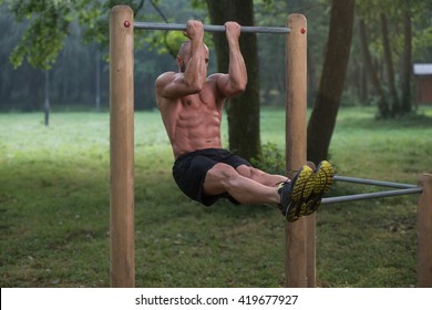 Young Athlete Working Out Biceps In An Outdoor Gym - Doing Street Workout Exercises