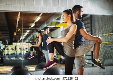 Young athletes exercising and stretching legs at the gym. - Shutterstock ID 571228462