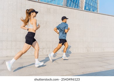 Young Athletes Running Together on an Urban Pathway Under a Clear Blue Sky During Daytime - Powered by Shutterstock